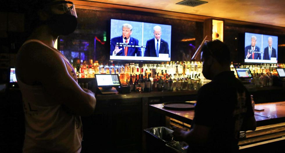 Los trabajadores usan protectores faciales durante una transmisión del debate final entre Trump y Biden en West Hollywood, California. (Mario Tama/Getty Images/AFP).