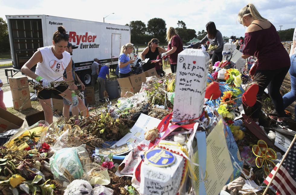 Voluntarios retiran objetos del memorial de Parkland tras robos. (AP)