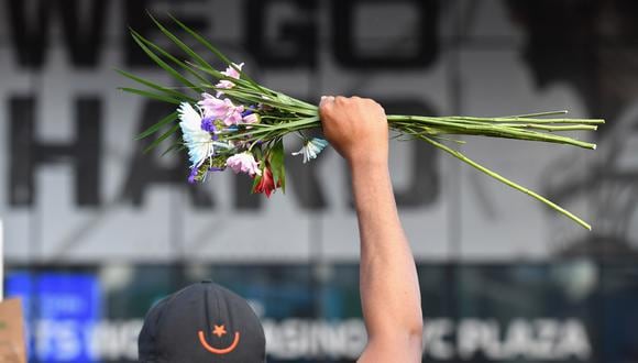 Un manifestante sostiene flores sobre su cabeza durante una protesta de "Black Lives Matter" cerca del Barclays Center en el distrito de Brooklyn de la ciudad de Nueva York, indignado después de que George Floyd, un hombre afroamericano desarmado, muriera mientras era arrestado por la policía en Minneapolis. (Foto: AFP/Angela Weiss)