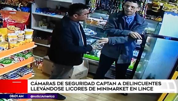 En las imágenes difundidas por América Noticias, se observa como dos hombres vestidos de terno y corbata ingresan a la tienda y hacen el ademan de que van a comprar. (América Tv)