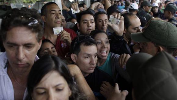 Militares venezolanos tratan de clamar a ola de compradores afuera de la tienda Daka en Caracas. (AP)