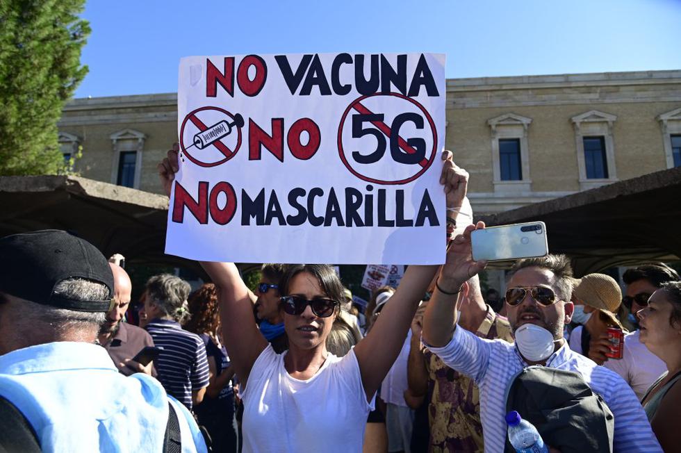 Una mujer sostiene un cartel que dice "Sin vacuna, sin 5G, sin mascarilla" durante una manifestación contra el uso obligatorio de mascarillas, así como otras medidas adoptadas por el gobierno español para luchar contra el coronavirus. (Foto: Javier Soriano / AFP)