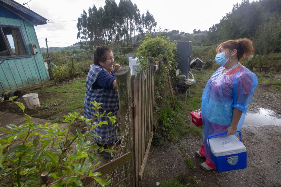 Ximena Ampuero llega a una casa para vacunar a ancianos contra el COVID-19 en la isla de Chiloé, a unos 1.230 km al sur de Santiago, el 16 de abril de 2021.  (ALVARO VIDAL / AFP).