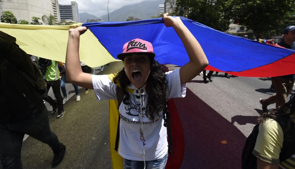 Manifestantes se agrupan en diferentes puntos de Caracas para marchar por la principal autopista de la ciudad. (AFP)