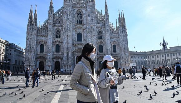 Dos mujeres con una máscara protectora caminaron por la Piazza del Duomo, en el centro de Milán. (Foto: AFP)