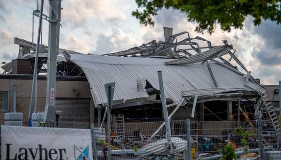 El techo de un concesionario de maquinaria de construcción se encuentra al otro lado del edificio en Paderborn, Alemania occidental, el 20 de mayo de 2022, después de que una tormenta causara daños importantes. - Más de 30 personas resultaron heridas, incluidas 10 de gravedad, el 20 de mayo en un "tornado" que azotó la ciudad de Paderborn, en el oeste de Alemania, dijo a la AFP un portavoz de la policía. El tornado también causó daños significativos en la ciudad en el estado de Renania del Norte-Westfalia, dijo, luego de temperaturas anormalmente altas para la época del año. (Foto de Lino Mirgeler / dpa / AFP)