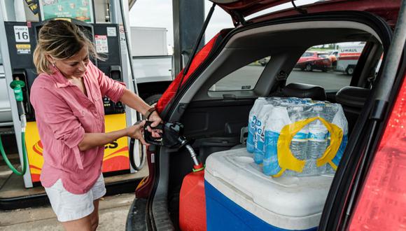 Jennifer Tate llena una lata de gasolina junto a agua embotellada y otros suministros mientras se prepara para la llegada del huracán Ida en Pass Christian, Mississippi, Estados Unidos, el 27 de agosto de 2021. (EFE/EPA/DAN ANDERSON).