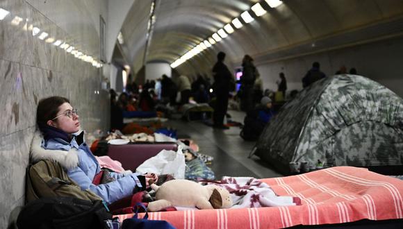 Una mujer joven se sienta en una estación de metro subterránea utilizada como refugio antibombas en Kiev el 2 de marzo de 2022. - En el séptimo día de combates en Ucrania, Rusia reclama el control el 2 de marzo de 2022 de la ciudad portuaria sureña de Kherson, las batallas callejeras estallan en Kharkiv, la segunda ciudad más grande de Ucrania, y Kyiv se preparan para un temido asalto ruso. (Foto de Aris Messinis/STF/AFP)