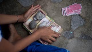 Niños de un pueblo venezolano juegan a las cartas con bolívares en desuso