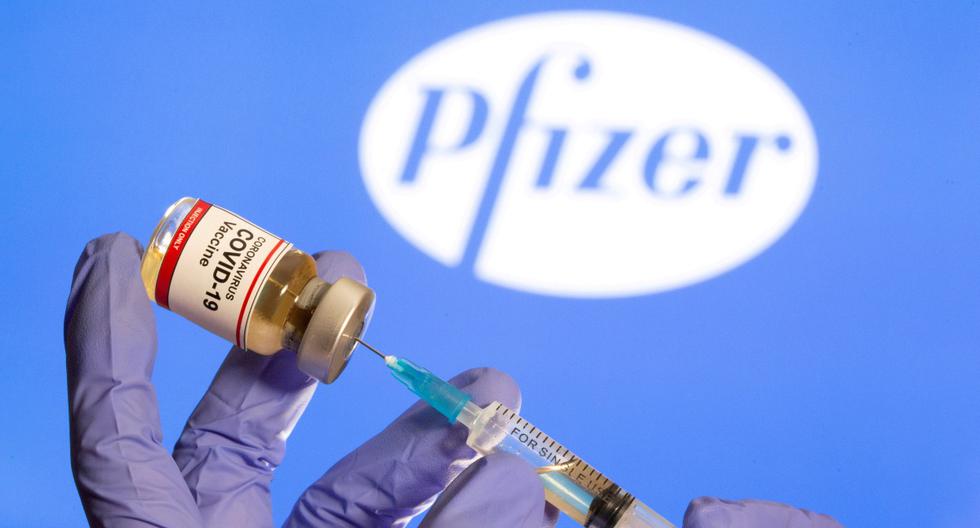 Una mujer sostiene una pequeña botella con una etiqueta que dice "Vacuna contra el coronavirus (COVID-19)" y una jeringa médica frente al logotipo de Pfizer. Ilustración tomada el 30 de octubre de 2020. (REUTERS/Dado Ruvic).