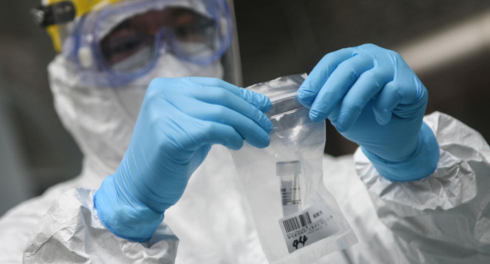 Imagen referencial. Un médico de China es visto realizando análisis sobre el nuevo coronavirus. (AFP/STR).