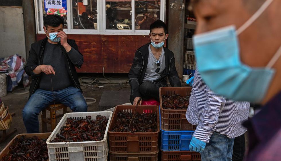 En un gran mercado de alimentos en la ciudad china de Wuhan los carteles prohíben la venta de animales salvajes y aves de corral, mientras los altavoces reproducen una y otra vez mensajes que celebran la “victoria” sobre el nuevo coronavirus. (Héctor RETAMAL / AFP).