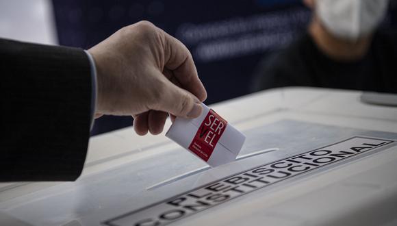 Un miembro del Servel (Servicio Electoral) muestra cómo emitir su voto en un colegio electoral antes del referéndum del próximo domingo en Santiago el 2 de septiembre de 2022. (Foto por MARTÍN BERNETTI / AFP)