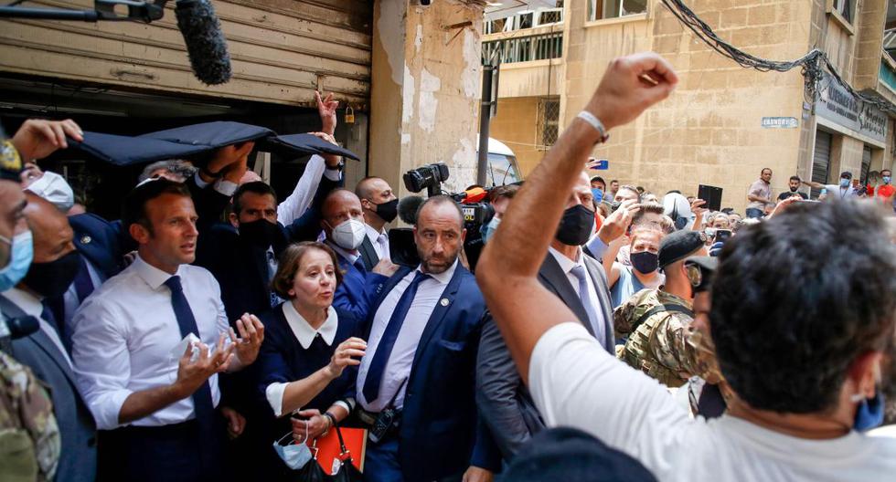 Emmanuel Macron (izquierda) hace gestos cuando visita una devastada calle de Beirut, Líbano. (AFP / POOL / Thibault Camus).