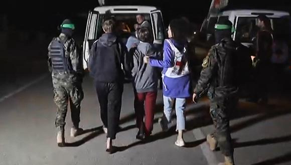 Combatientes de Hamás acompañan a rehenes israelíes recién liberados a un vehículo de la Cruz Roja en la Franja de Gaza el pasado 27 de noviembre de 2023. (AFP).