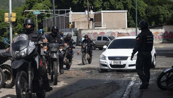 Integrante de la Policía Nacional Bolivariana ingresa al barrio El Valle en las inmediaciones de la Cota 905, durante enfrentamientos contra presuntos integrantes de una banda criminal en Caracas. (Yuri CORTEZ / AFP)