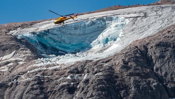 Un helicóptero de rescate vuela el 4 de julio de 2022 sobre el glaciar que se derrumbó el día anterior en la montaña de Marmolada, la más alta de los Dolomitas, un día después de que se registrara una temperatura récord de 10 grados Celsius (50 grados Fahrenheit) en el cumbre del glaciar. (Foto de Pierre TEYSSOT / AFP)