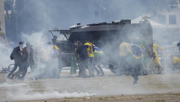 Los manifestantes, partidarios del expresidente de Brasil, Jair Bolsonaro, atacan vehículos blindados de la policía mientras asaltan el Palacio de Planalto en Brasilia, Brasil.