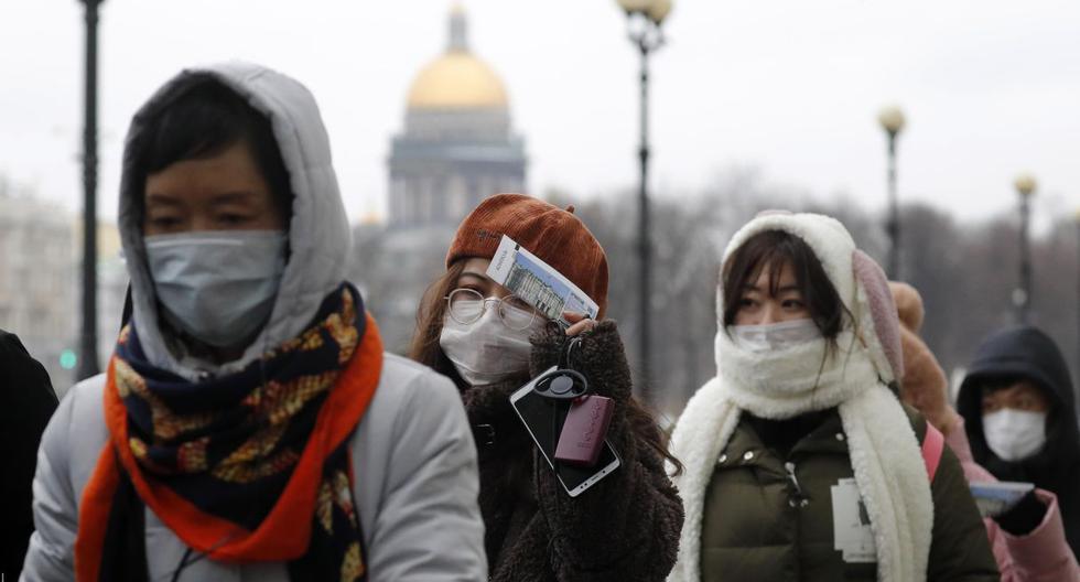 Los turistas chinos usan máscaras protectoras en la plaza Dvortsovaya en el centro de San Petersburgo en Rusia. (EFE).