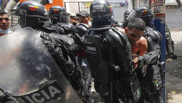 Vendedores ambulantes confrontan a miembros del Escuadrón Móvil Antidisturbios (ESMAD) luego de que no les permitieran seguir trabajando, en Cúcuta, Colombia, cerca de la frontera con Venezuela, el 29 de marzo de 2022. (Foto de Schneyder MENDOZA / AFP)
