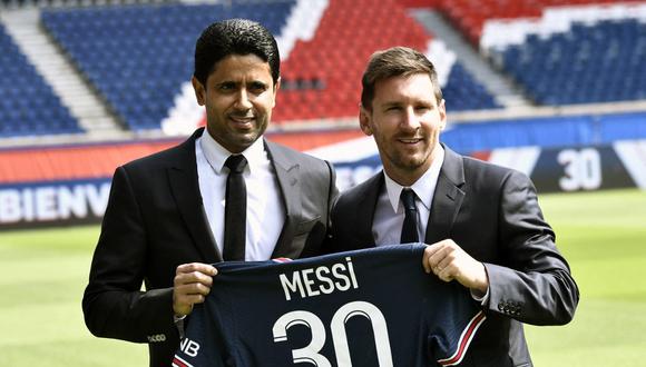 El presidente del Paris Saint-Germain, Nasser Al-Khelaifi (L), posa junto al jugador de fútbol argentino Lionel Messi mientras sostiene su camiseta con el número 30 en el Estadio Parc des Princes. (STEPHANE DE SAKUTIN / AFP)