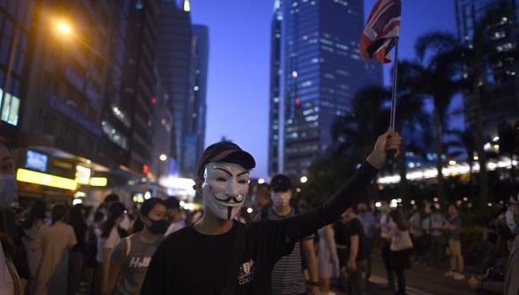 Un hombre que lleva una máscara y sostiene una bandera británica se une a los manifestantes mientras se reúnen en el corazón del Distrito Comercial Central de Hong Kong el 4 de octubre de 2019. (Foto: AFP)