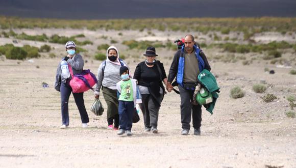 Una familia migrante venezolana camina por el desierto después de cruzar ilegalmente la frontera entre Bolivia y Chile, en Colchane. (IGNACIO MUNOZ / AFP)