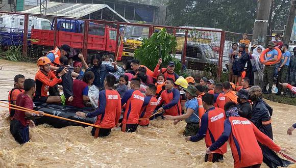 Imagen muestra a los rescatistas evacuando a los residentes de sus casas inundadas en medio de las fuertes lluvias provocadas por el tifón Rai en la ciudad de Cagayán de Oro, en la isla sureña de Mindanao, Filipinas. (Foto: Philippine Coast Guard (PCG) / AFP)