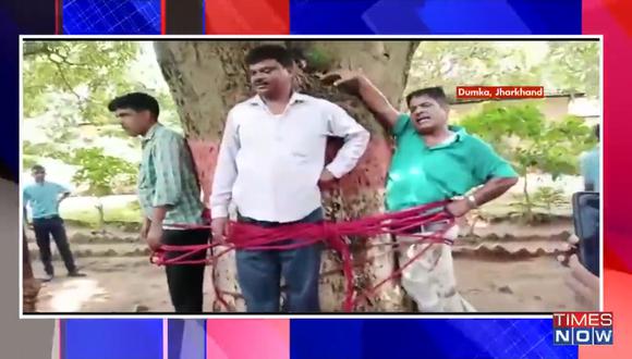 el profesor Suman Singh y dos funcionarios educativos son atados a un árbol. (Foto: Captura de video)