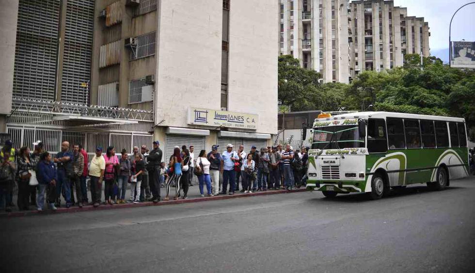 La gente espera en la cola para abordar un autobús en Caracas, Venezuela, el 14 de marzo de 2019. (Foto: AFP)