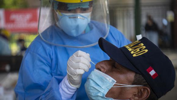 Un hombre se hace la prueba de la enfermedad del coronavirus COVID-19 en un centro de salud ubicado en la calle en Lima el 11 de enero de 2022. - COVID-19 mató al menos a un padre o cuidador principal de casi 100,000 niños en Perú, el país con el la tasa de mortalidad por coronavirus más alta del mundo, informó su gobierno la semana pasada. (Foto de Ernesto BENAVIDES / AFP)