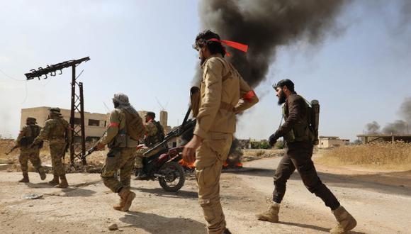 Combatientes del Frente de Liberación Nacional mantienen posición protegiéndose de los ataques aéreos de las fuerzas del régimen, en la provincia siria de Hama. (Foto: AFP)