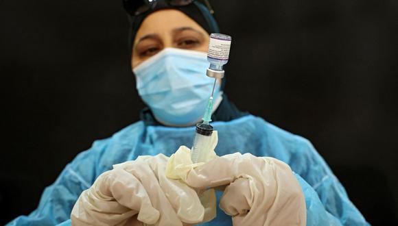 Una empleada del Ministerio de Salud de Palestina prepara una dosis de la vacuna contra el coronavirus durante una campaña de vacunación de Pfizer-BioNTech y Moderna en la aldea de Dura, al oeste de Hebrón. (HAZEM BADER / AFP).
