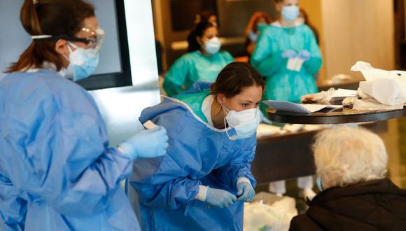 Los trabajadores de la salud atienden a una paciente con COVID-19 a su llegada al Hotel Meliá Barcelona Sarrià, ya que el hotel se transformó en una estructura médica para tratar los casos menos graves en medio del brote causado por el nuevo coronavirus. (Foto: AFP/Pau Barrena)