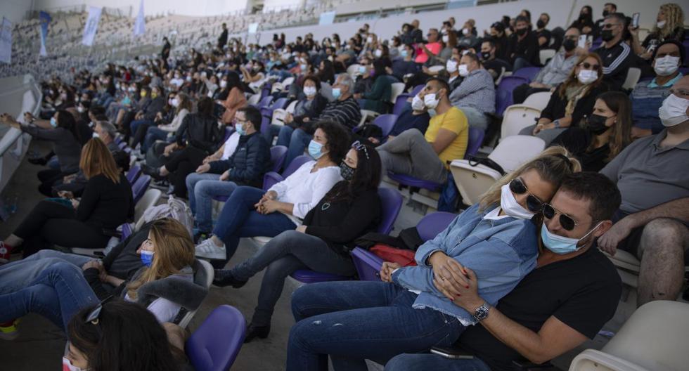 Israel, donde más de la mitad de la población ha recibido como mínimo una primera dosis de la vacuna, empezó a salir de su tercer confinamiento de forma progresiva, a principios de febrero. Imagen de las personas en la tribuna de un estadio en Tel Aviv.  (Texto: AFP / Foto: AP).
