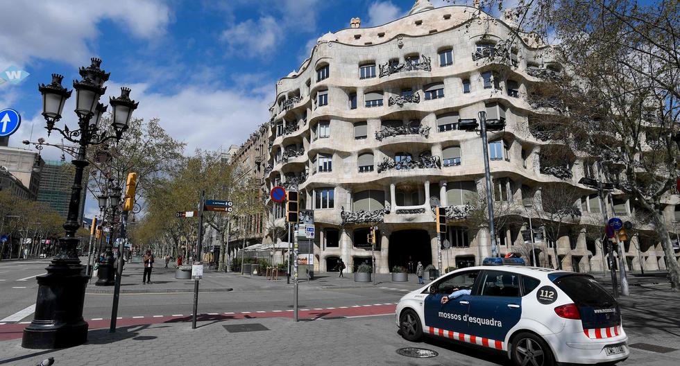 Un auto de la policía de Catauña delante de la Pedrera de Gaudí. Las calles se muestran vacías por el confinamiento del coronavirus. (Josep Lago/AFP).