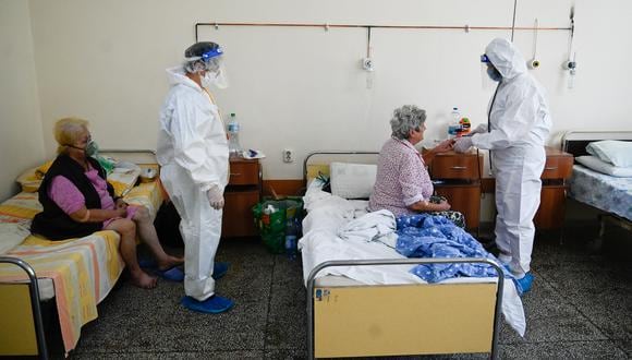 Un médico y una enfermera examinan a los pacientes en la unidad Covid-19 de un hospital en Kjustendil el 19 de octubre de 2021, uno de los municipios de la 'zona roja oscura de Covid' de Bulgaria. (Foto: Nikolay DOYCHINOV / AFP)