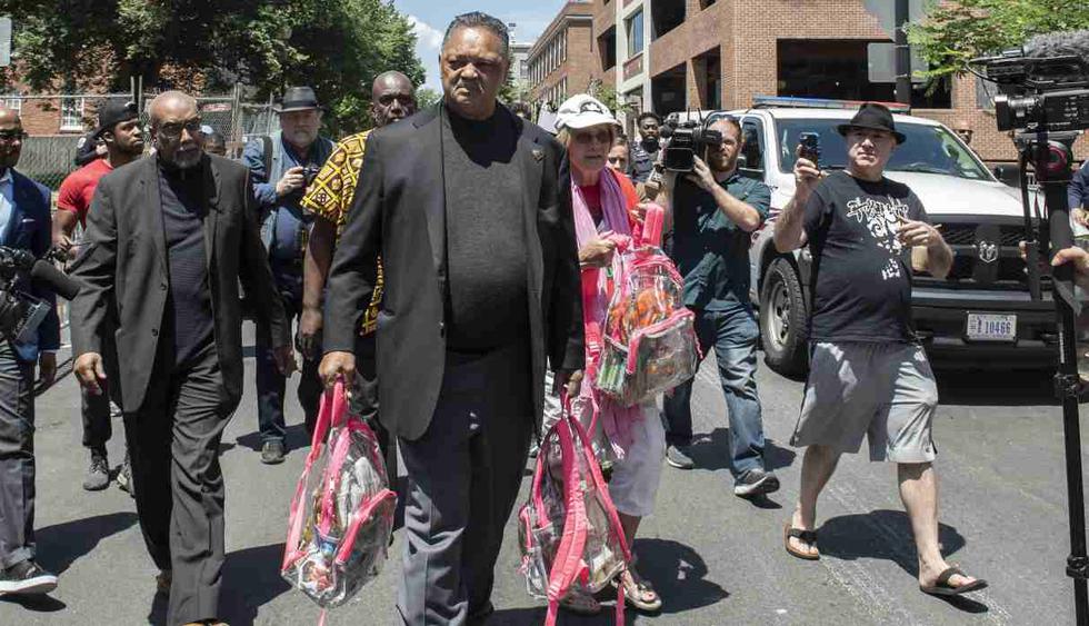 El reverendo Jesse Jackson lleva bolsas de comida y agua cuando llega para apoyar a los activistas que ocupan la embajada venezolana en Washington. (Foto: AFP)