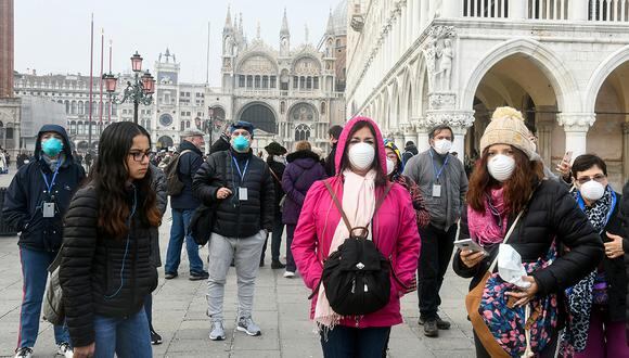 Los turistas con máscaras protectoras visitan Venecia, durante el período habitual de las festividades del Carnaval que se han cancelado tras un brote del nuevo coronavirus Covid-19 en el norte de Italia. (Foto: AFP)