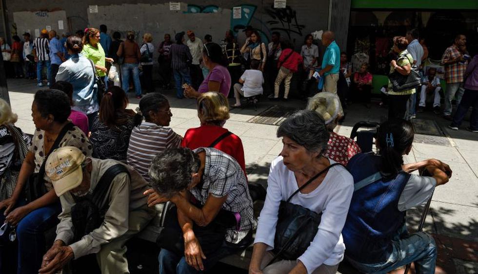 Miles de ancianos en Venezuela se vieron obligados hacer largas filas por más de cinco horas para cobrar una parte de su pensión en efectivo. | Foto: AFP