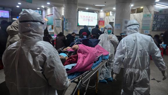 Personal médico con ropa protectora atiende a un paciente de coronavirus en el Hospital de la Cruz Roja de Wuhan. (Foto: AFP)