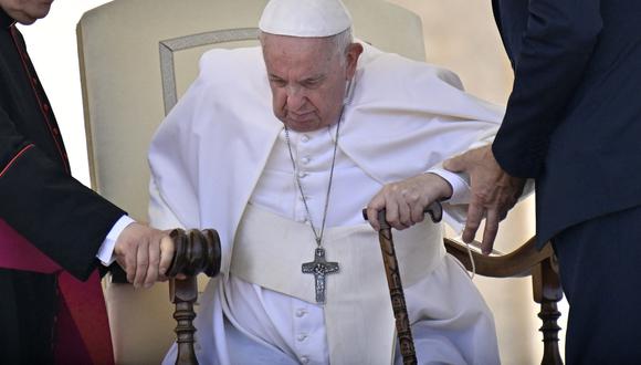 Ayudan al papa Francisco a levantarse de su asiento al final de la audiencia general semanal el 8 de junio de 2022 en la Plaza de San Pedro en el Vaticano. (Foto de Alberto PIZZOLI / AFP)