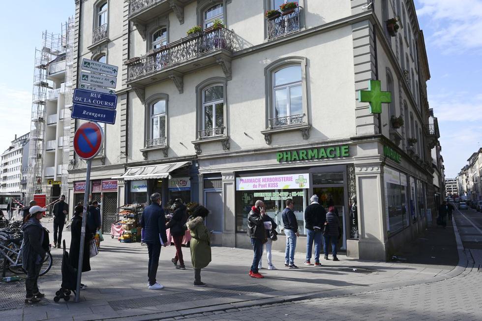 La gente hace cola frente a una farmacia en Estrasburgo, este de Francia, a medida que entra en vigor la orden de quedarse en casa para todos los ciudadanos franceses. (Foto: AFP)