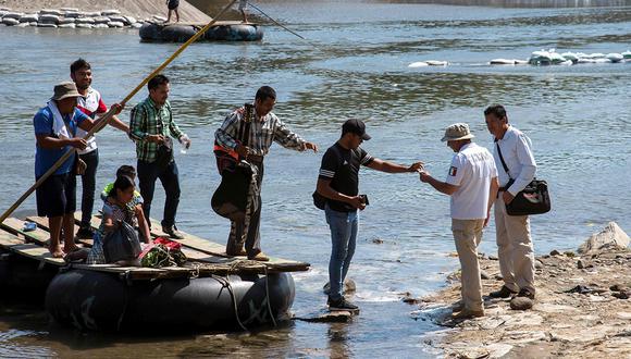 Un oficial de migración mexicano verifica la identificación de personas que cruzan el río Suchiate, en un puesto de control en Ciudad Hidalgo, estado de Chiapas, México. (Foto: AFP)