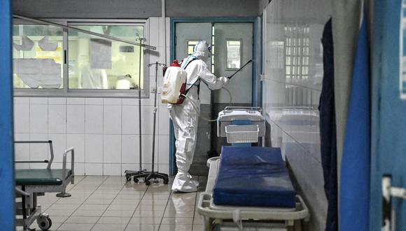 Un agente del Instituto Nacional de Higiene Pública (INHP) con traje de equipo de protección personal (EPP) contra el virus del Ébola desinfecta las instalaciones de un hospital. (Foto: Sia KAMBOU / AFP)