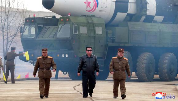 Esta fotografía tomada el 24 de marzo de 2022 y publicada por la Agencia Central de Noticias de Corea (KCNA) oficial de Corea del Norte el 25 de marzo de 2022 muestra al líder norcoreano Kim Jong Un (centro) caminando cerca de lo que los medios estatales dicen que es un nuevo tipo de balística intercontinental. (Foto de varias fuentes / AFP)