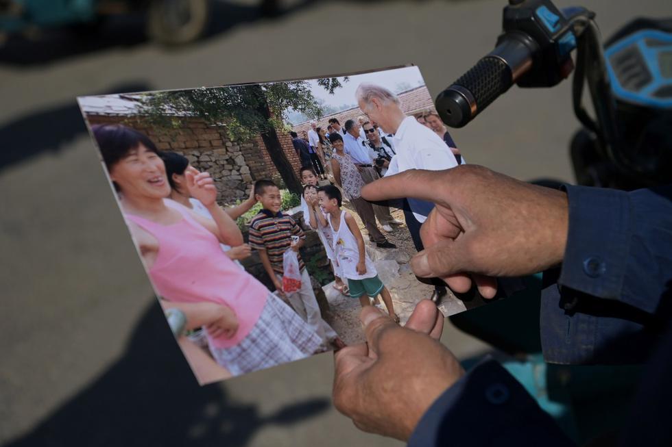 La mayoría de los habitantes guarda un recuerdo bastante vago de la visita, pero las fotos de la AFP muestran a niños y padres reunidos en torno a un Joe Biden sonriente. (AFP / GREG BAKER).