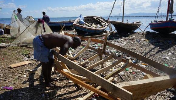 Un haitiano construye el marco de un nuevo barco en Cap-Haitien, Haití. (Foto: AFP)