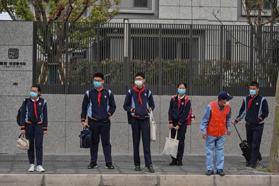 Los estudiantes con máscaras faciales llegan a la Escuela Intermedia Huayu en Shanghai el 27 de abril de 2020. (Foto: AFP/Hector Retamal)