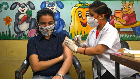 Un trabajador de la salud inocula a una mujer con una inyección de la vacuna contra el COVID-19 en Nueva Delhi. (Money SHARMA / AFP)